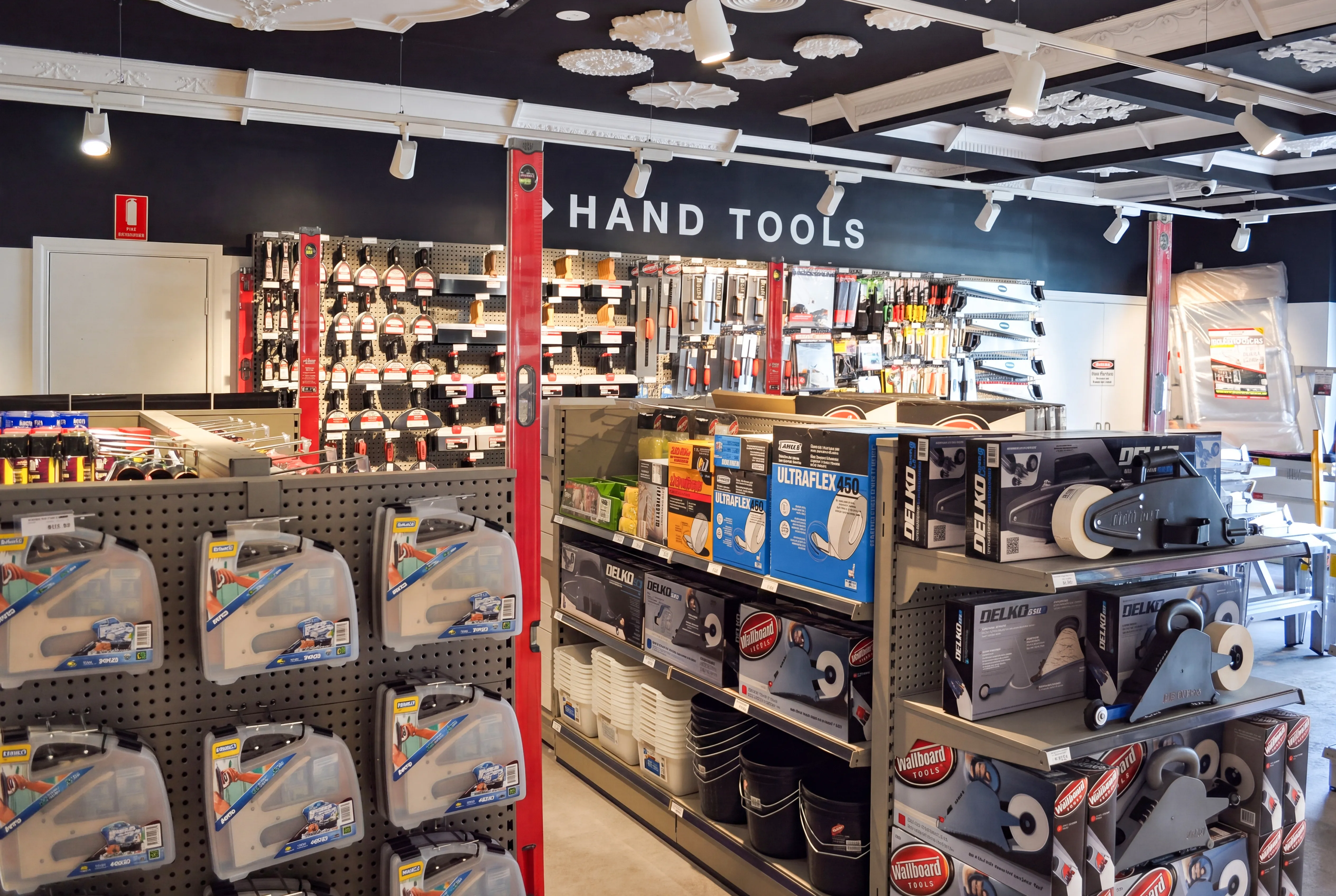 A hardware store aisle stocked with hand tools, including levels, putty knives, tape dispensers, and buckets.CSR Picton Hopkins Gondola Racking