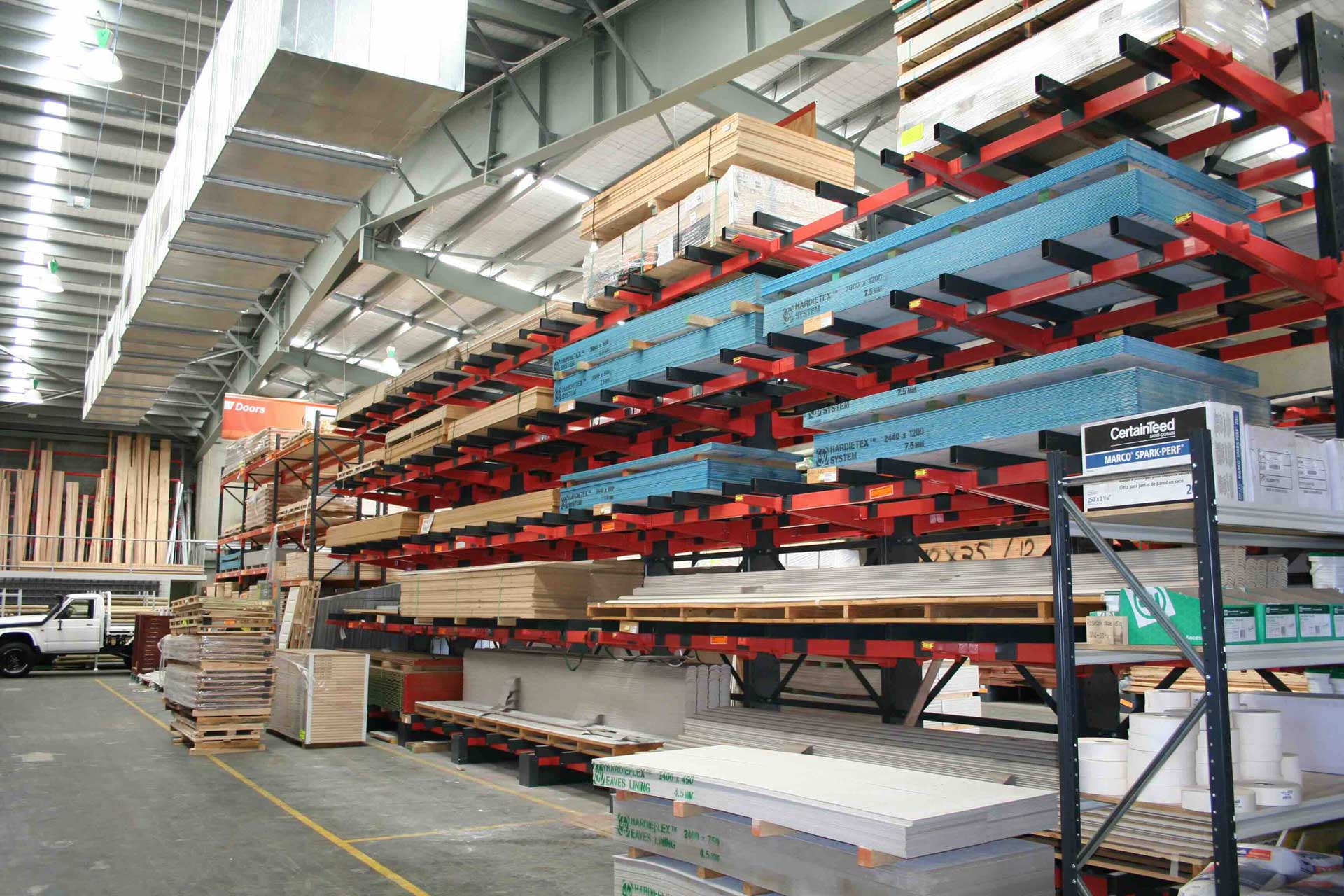 Cantilever Spreader System racking holding stacked sheets of plywood and construction materials.